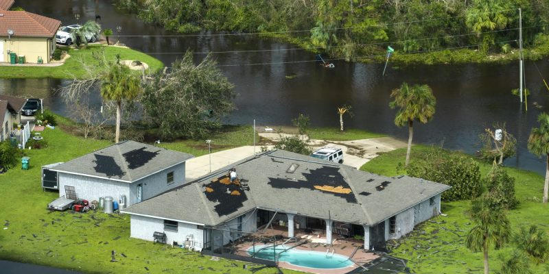 Hurricane Ian destroyed house with damaged roof and lanai enclosure