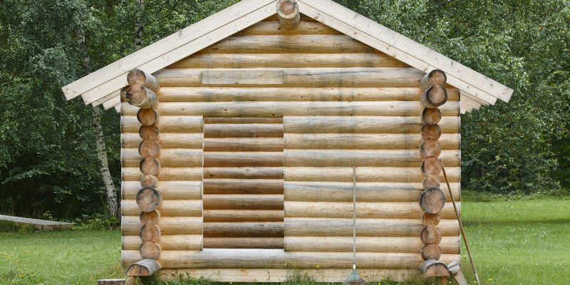 Wooden cabin in the forest under construction. Raw materials. Finland